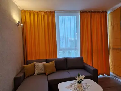 a living room with a couch and a window at Sunset Apartment Atlantis Resort in Burgas City