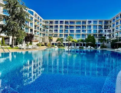 a large swimming pool in front of a large building at Sunset Apartment Atlantis Resort in Burgas City
