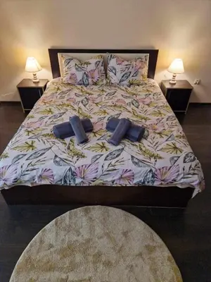 a bed with two pillows on it in a bedroom at Lazur Apartment AQUA in Burgas City