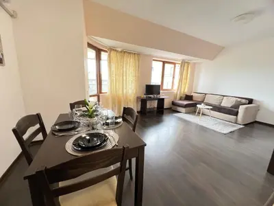 a living room with a table and chairs and a couch at Lazur Apartment AQUA in Burgas City
