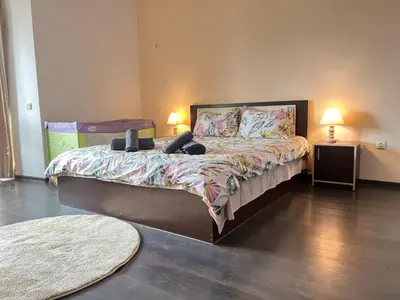 a bedroom with a large bed with two lamps at Lazur Apartment AQUA in Burgas City