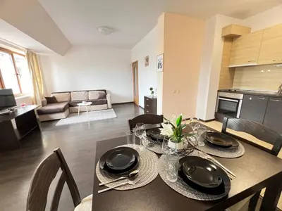 a living room with a dining table and a kitchen at Lazur Apartment AQUA in Burgas City