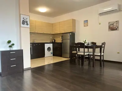 a kitchen and dining room with a table and chairs at Lazur Apartment AQUA in Burgas City