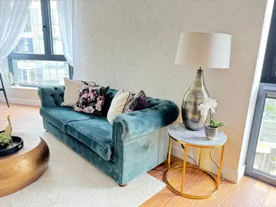 a living room with a blue couch and a table with a lamp at Anabel Home in Burgas City