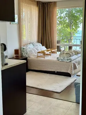 two beds in a room with a balcony at Apartment Porto Chernomoretz in Chernomorets