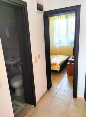 a bathroom with a toilet and a sink and a bed at Apartament Morela in Sunny Beach