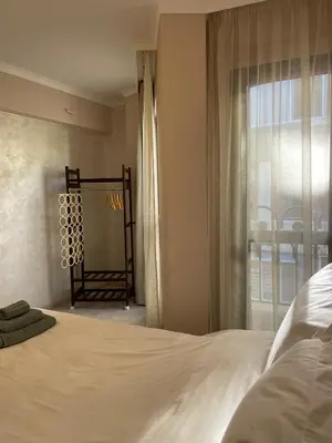 a bedroom with a large white bed and a window at Varna City Center Apartment in Varna City