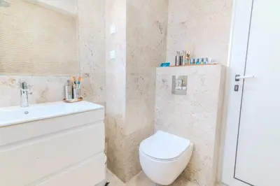 a bathroom with a white toilet and a sink at Sea Twins Luxury Aparthotel - 150 m from the beach in Sunny Beach