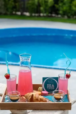 a tray of food with drinks and pastries on a table at Sea Twins Luxury Aparthotel - 150 m from the beach in Sunny Beach