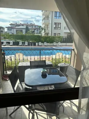 a table on a balcony with a view of a pool at Pool apartment on the beach in Burgas City