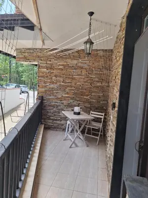a patio with a table and a brick wall at Green Paradise apartman 105 in Primorsko