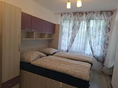 a small bedroom with two beds and a window at Apartment102 Green Paradise Primorsko in Primorsko