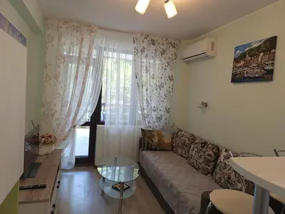 a living room with a couch and a window at Apartment102 Green Paradise Primorsko in Primorsko