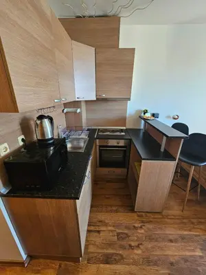 a small kitchen with wooden cabinets and a sink at Апатаменти за гости Sunshine и Glory in Sveti Vlas