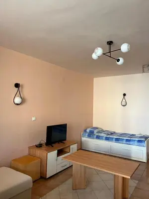 a room with a bed and a table with a tv at Seafront apartment Lucky in Sveti Vlas
