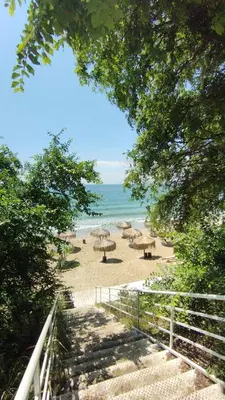 a view of a beach with umbrellas and the ocean at Seafront apartment Lucky in Sveti Vlas