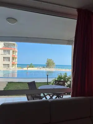 a living room with a couch and a large window at Seafront apartment Lucky in Sveti Vlas