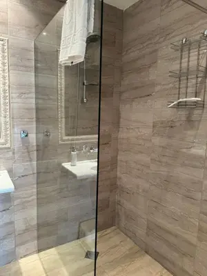 a bathroom with a shower with a sink and a mirror at Marteo Apartments103 - Sozopol in Sozopol