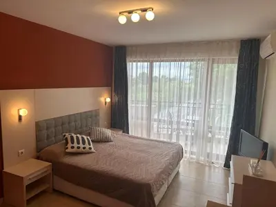 a bedroom with a bed and a large window at River Park Studio in Sunny Beach