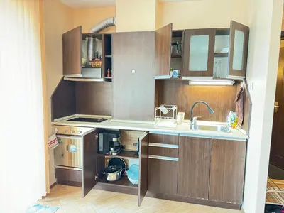 a kitchen with wooden cabinets and a sink at Stan u moru in Pomorie