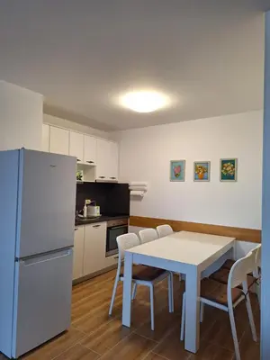 a kitchen with a white table and a white refrigerator at Созополи Хилс A11 in Sozopol