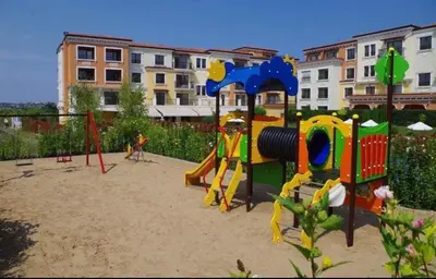a playground with a play equipment in the sand at Marteo Apartments 105 - Sozopol in Sozopol