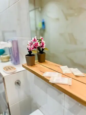 two flowers on a wooden counter in a bathroom at Boutique Sozopol in Sozopol