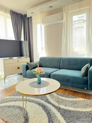 a living room with a blue couch and a table at Boutique Sozopol in Sozopol