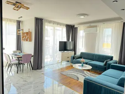 a living room with a blue couch and a table at Boutique Sozopol in Sozopol