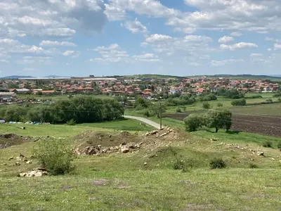 a green field with a town in the distance at Brymonte Studio, Sunny Day 6 in Tŭnkovo