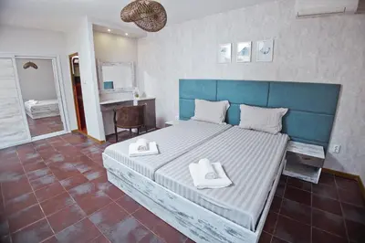 a bedroom with a large bed with two towels on it at Хотел и Вили Марая apartament in Tsarevo