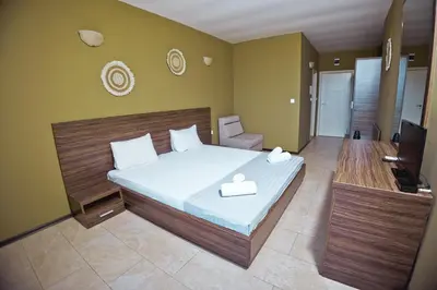 a bedroom with a bed and a television in it at Хотел и Вили Марая apartament in Tsarevo