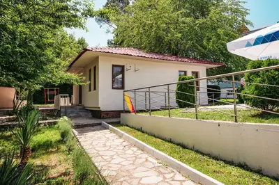 a small house with a balcony and an umbrella at Хотел и Вили Марая apartament in Tsarevo