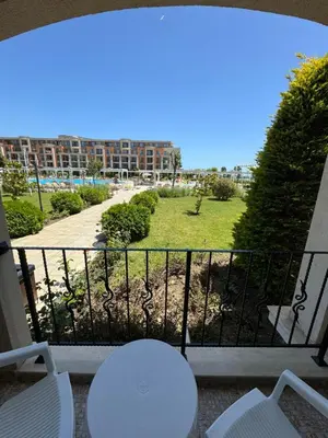 a balcony with a table and chairs and a park at Sea View Premier Fort Beach Sveti Vlas in Sunny Beach