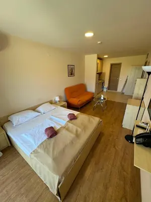 a bedroom with a large bed and an orange couch at Sea View Premier Fort Beach Sveti Vlas in Sunny Beach