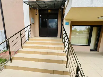 a staircase leading to a building with a black door at CHERNO MORE 107 - 19 APARTMENT Nessebar in Nesebar