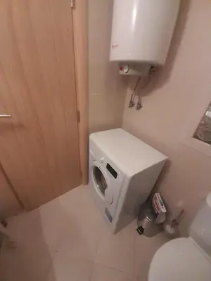 a small bathroom with a toilet and a paper dispenser at 2 Room Apartment Harmony Suites Komplex in Sunny Beach