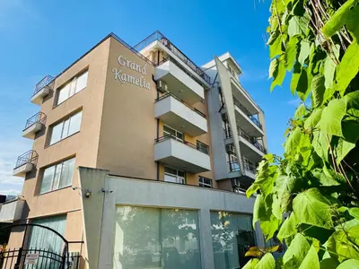 a building with a sign on the side of it at GRAND KAMELIA B 2,8 Large Studio Sunny Beach in Sunny Beach