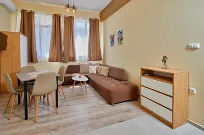 a living room with a couch and a table at Апартамент Пенека in Pomorie