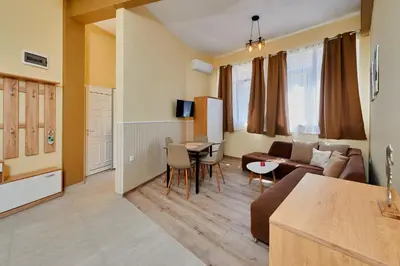 a living room with a couch and a table at Апартамент Пенека in Pomorie