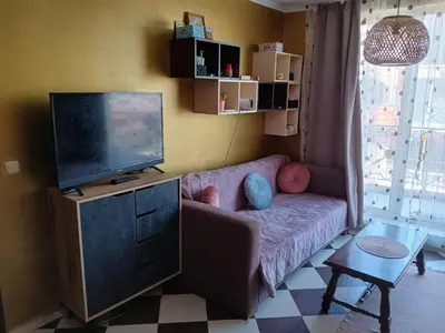 a living room with a couch and a flat screen tv at Golden Hacienda in Sozopol