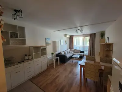 a kitchen and living room with a couch and a table at Prestige Fort Beach apartment in Sveti Vlas