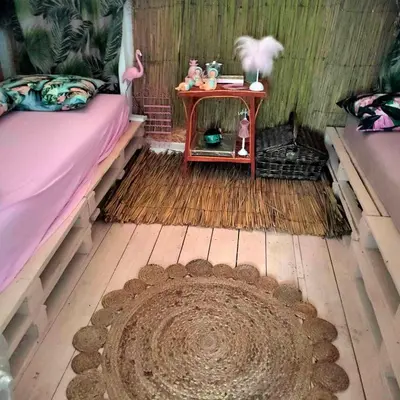 a room with a bed and a table and a rug at каравана ТРОПИК-ЕКЗОТИК А 17 in Sozopol