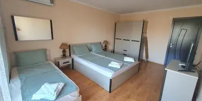 a small bedroom with a bed and a chair at Sunny Day Pomorie in Pomorie