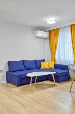 a living room with a blue couch and a table at The little things apt - Parking & Own EV Chаrgеr by Flat Mаnаger in Burgas City
