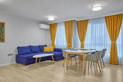 a living room with a blue couch and a table at The little things apt - Parking & Own EV Chаrgеr by Flat Mаnаger in Burgas City