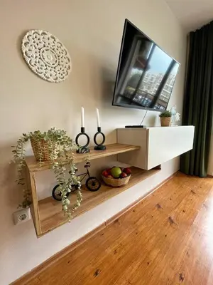 a living room with a flat screen tv on a shelf at GreenStudio w Sveti Vlas in Sveti Vlas