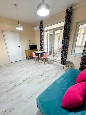 a room with a bed and a table and chairs at Flamingo Top Center Apartment in Varna City
