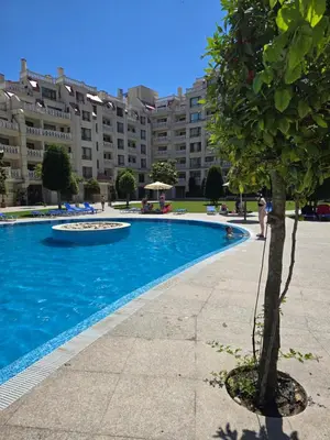 a swimming pool in front of a large building at South Bay Apartment - Varna in Varna City