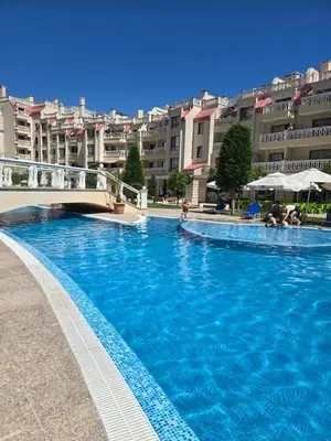 a large blue swimming pool with buildings in the background at South Bay Apartment - Varna in Varna City